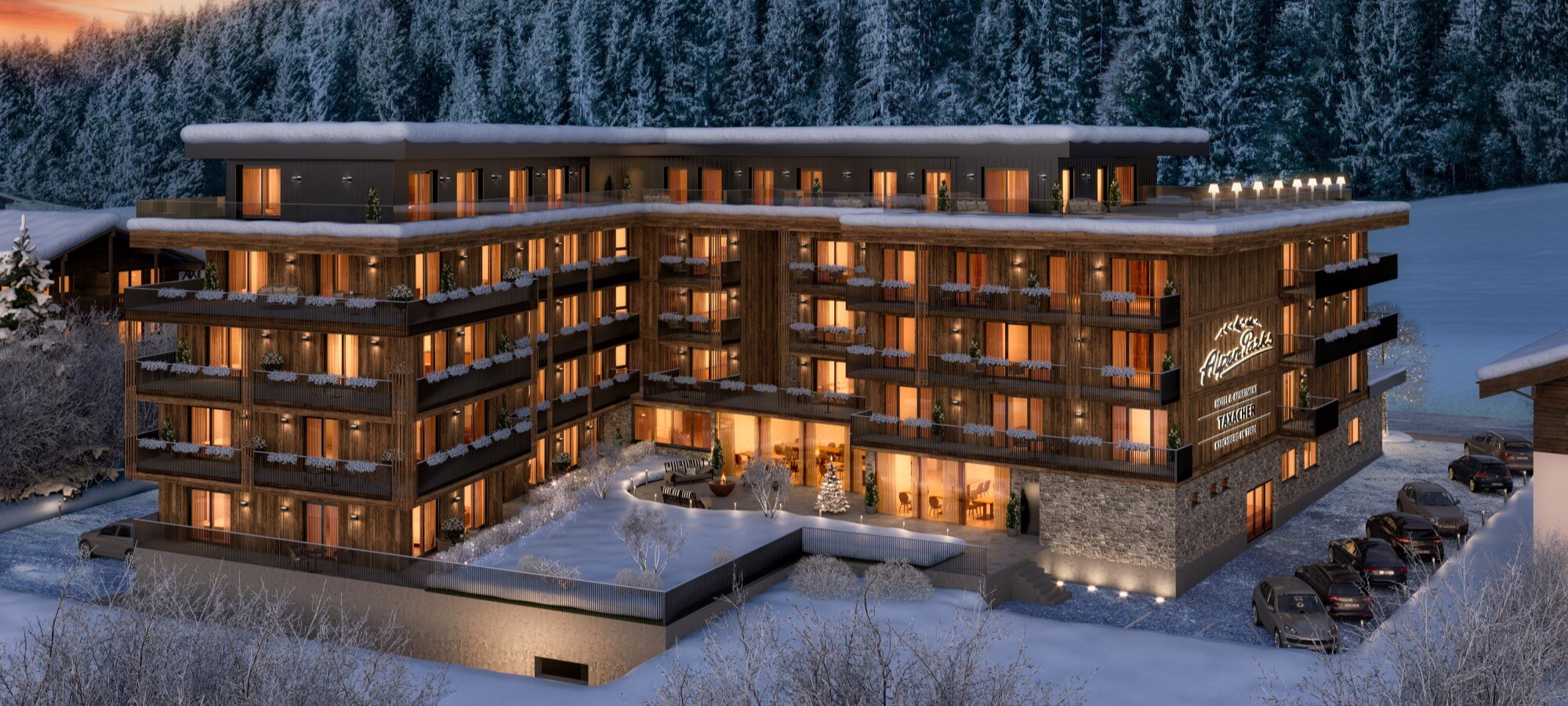 Abendliche Winteraufnahme des AlpenParks Taxacher in Kirchberg in Tirol, Österreich. Moderne Ferienimmobilien inmitten schneebedeckter Landschaft und Wälder, ideal für Investitionen in den österreichischen Alpen. Luxuriöse Apartments mit Balkonen, gemütlich beleuchtet, perfekt für Wintersport und Erholung.