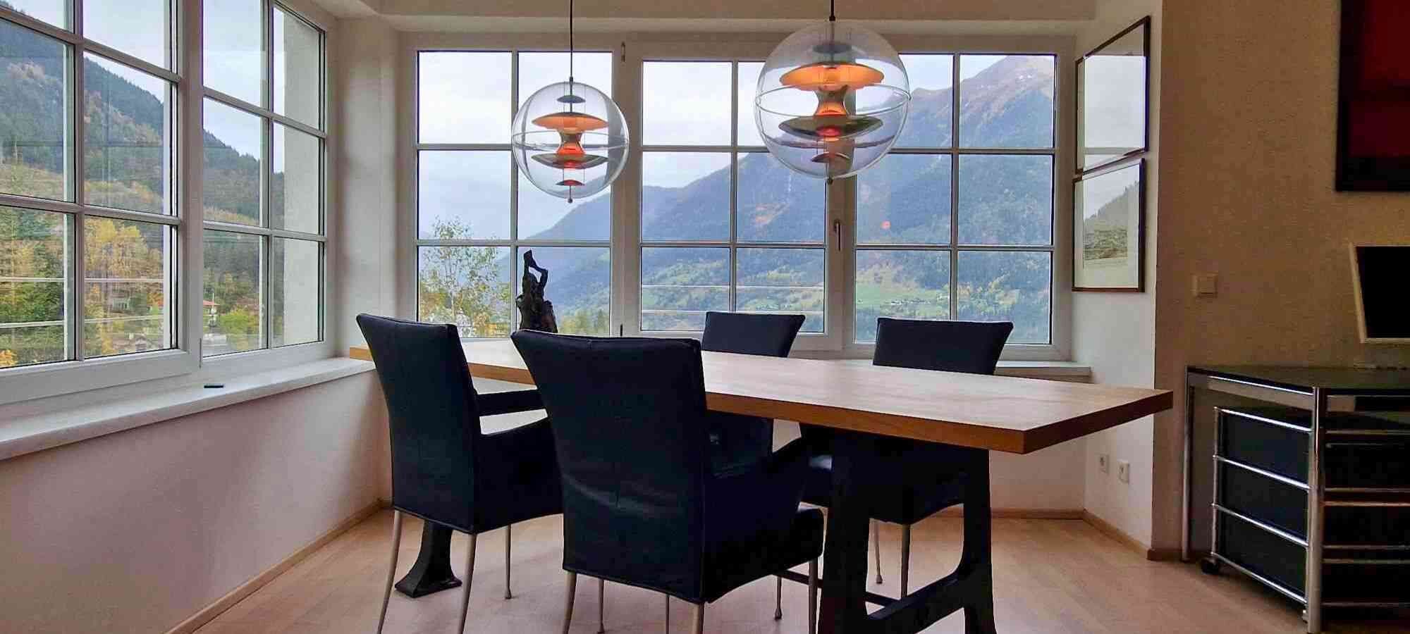Essbereich mit Fensterfront im Hintergrund mit Blick auf Bad Gastein.