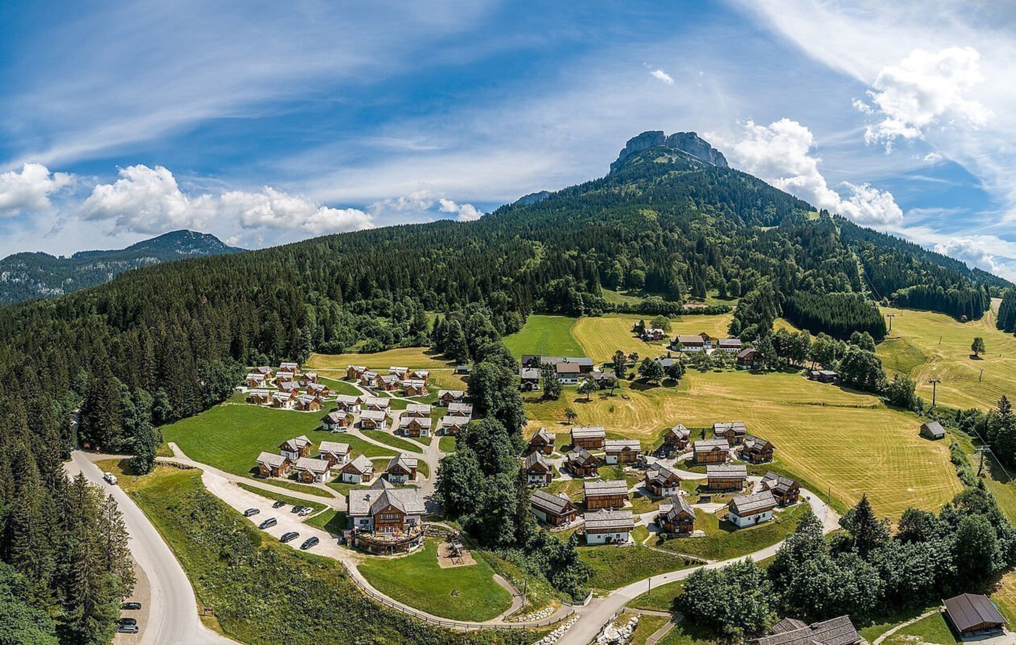 Die Apartmentanlage Hagan Lodge von AlpenParks von oben im Sommer. Im Hintergrund sieht man den Berg Loser.