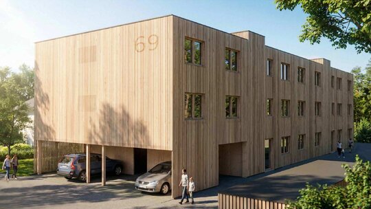 Seitenansicht des modernen Holzhauses mit Zweiraumwohnungen und Holzfassade in Feldkirch-Tosters