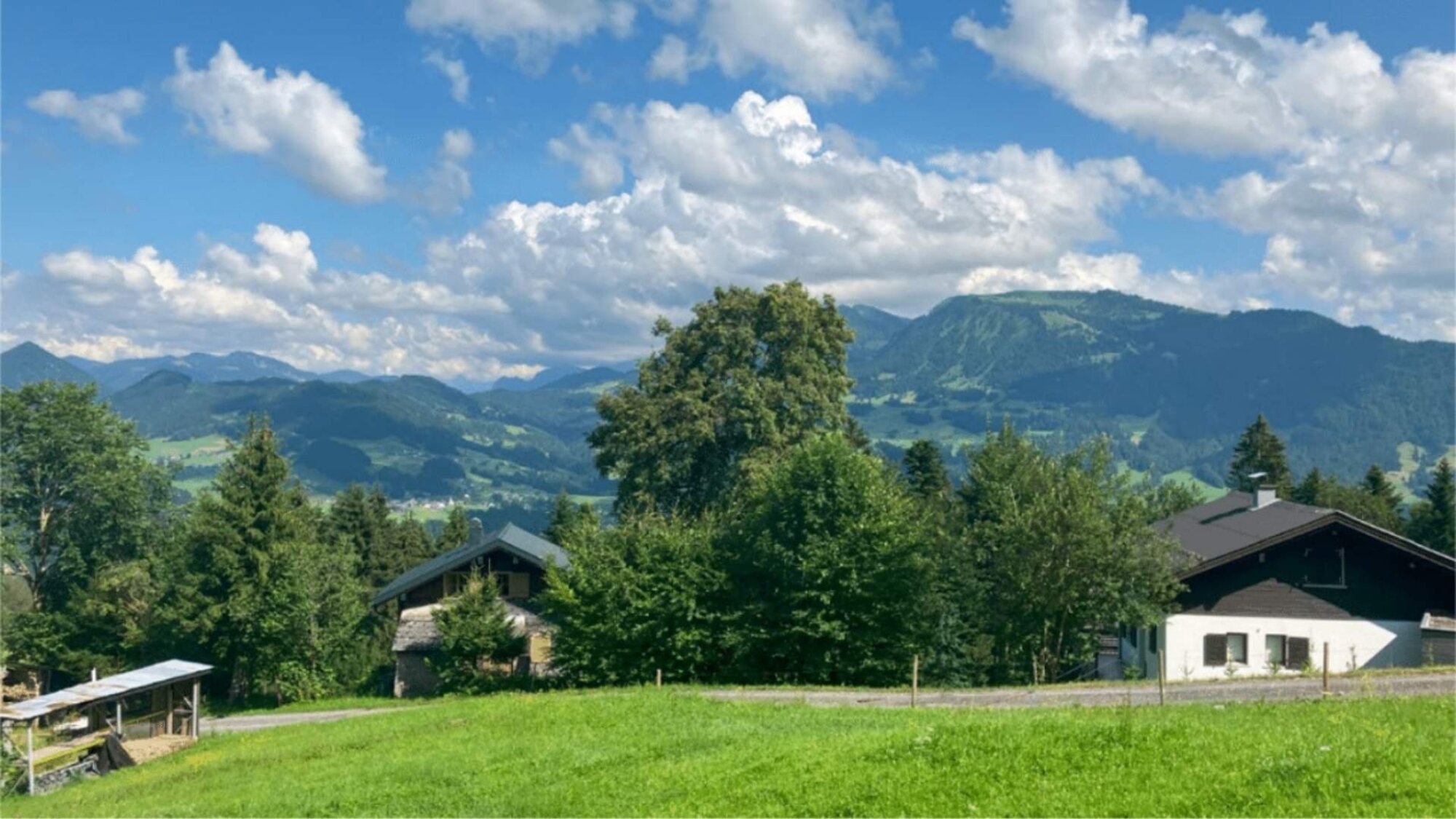 Sommerlicher Ausblick über die Gemeinde Egg mit Bergen und Wäldern, Vorarlberg, Österreich