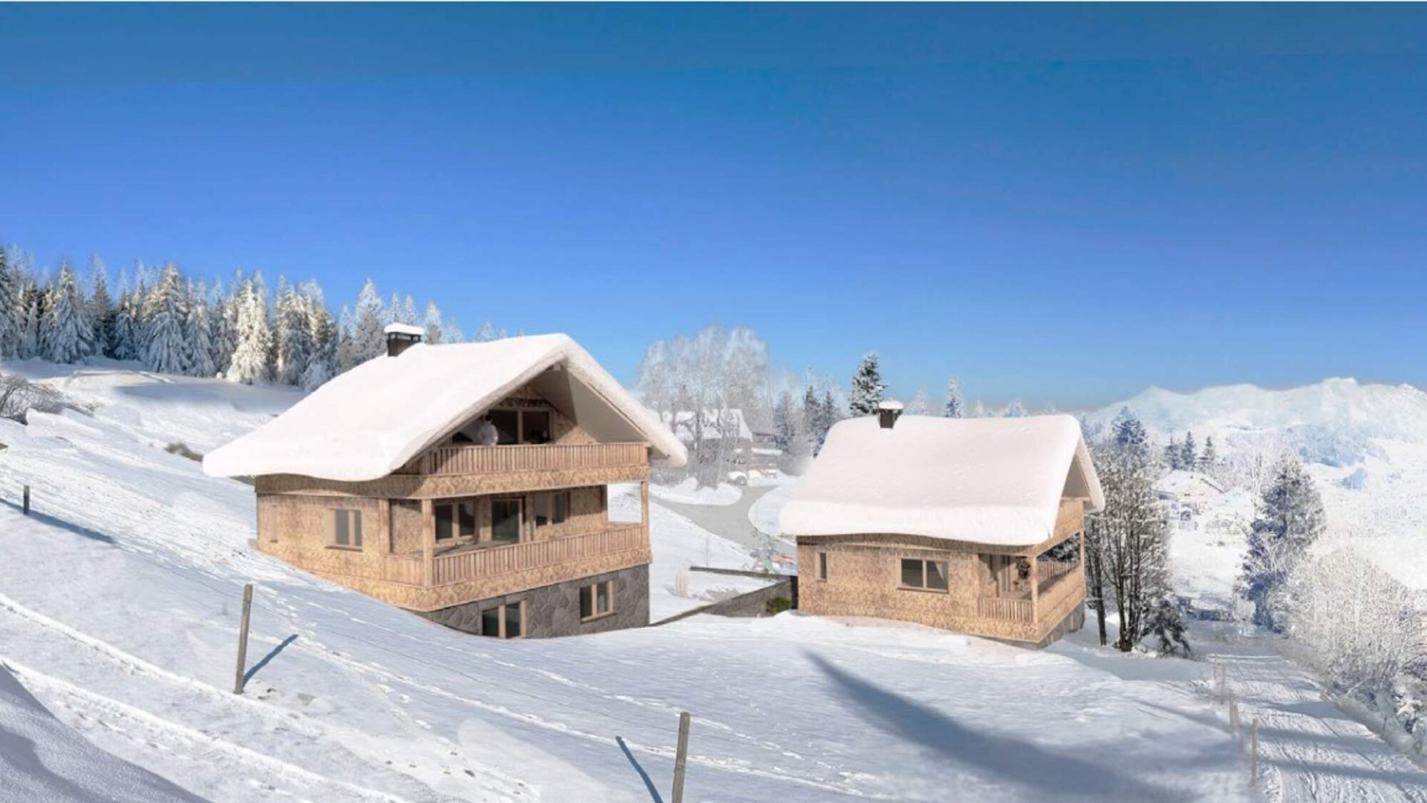 Zwei verschneite Ferienchalets im Winter auf Bergwiese mit Alpenblick in Egg, Vorarlberg