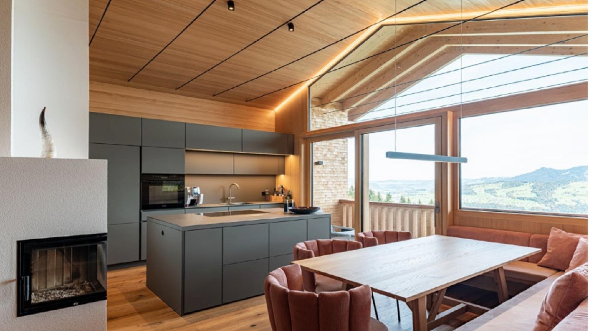 Offene Küche mit Kochinsel, Kamin und Panoramafenster im Ferienchalet in Egg, Vorarlberg