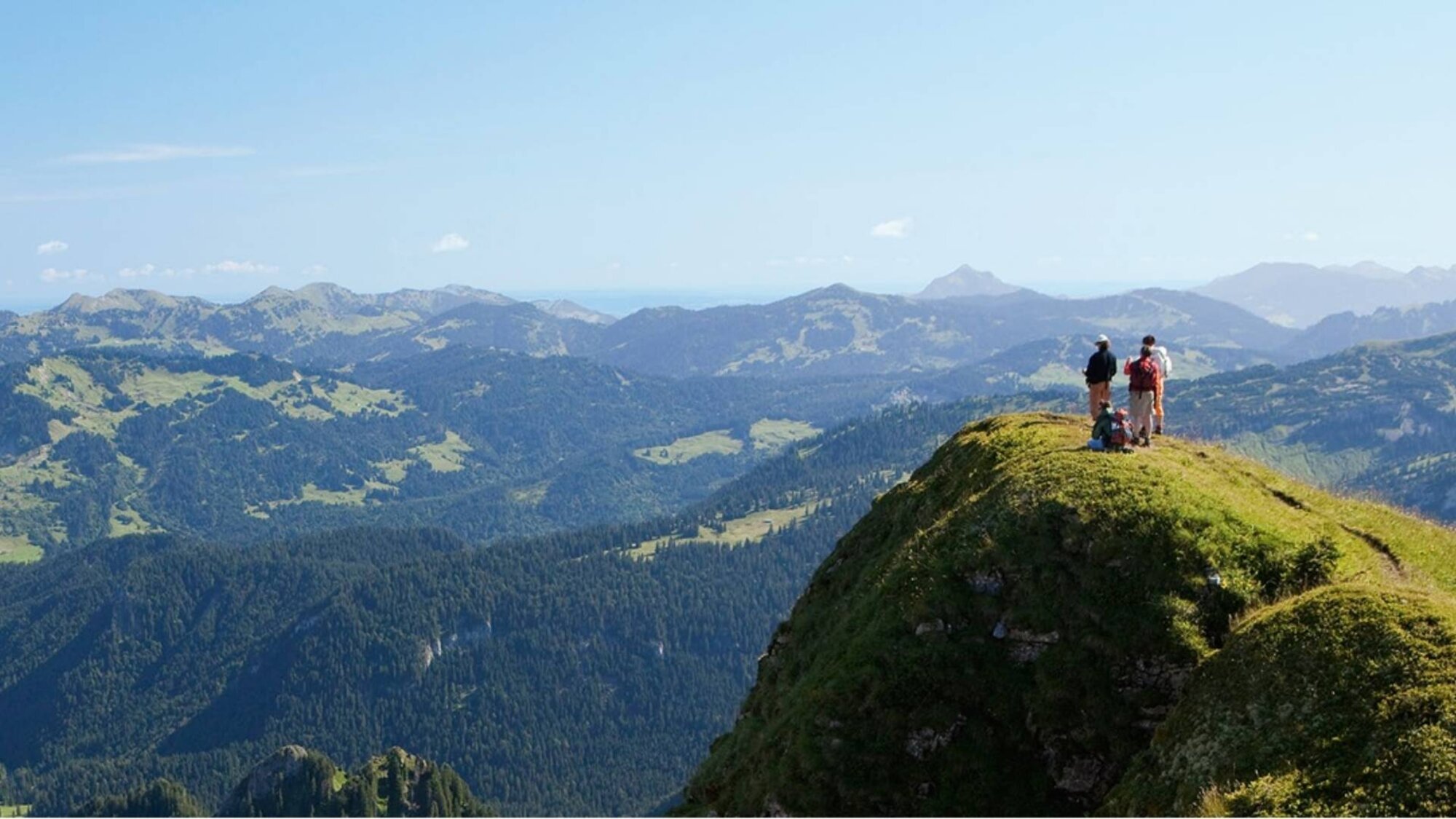 Frau auf dem Balkon des Ferienchalets mit Bergblick im Abendlicht in Egg, Vorarlberg