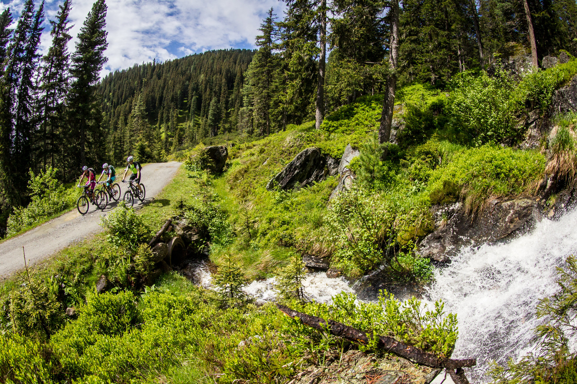 Radfahrer in den Alpen bei Bach
